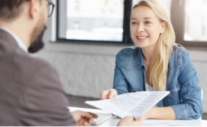 Femme souriante en entretien d'embauche, présentant son cv avec CVInMinutes.com.