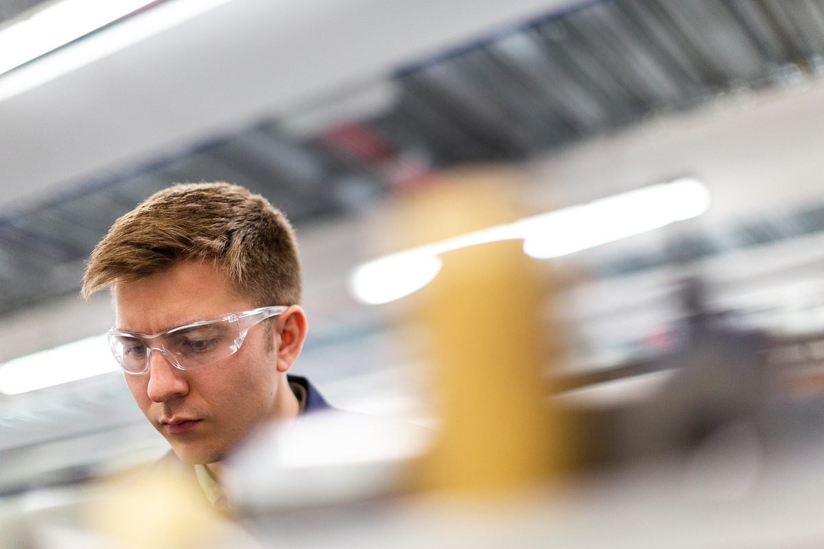 Un homme en sécurité travaille attentivement sur un équipement industriel Un homme en sécurité travaille attentivement sur un équipement industriel