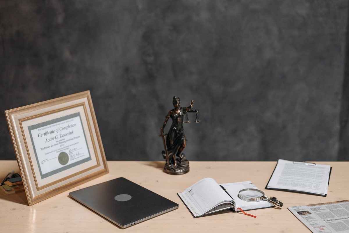 Bureau avec certificat, statue de justice, livre ouvert et documents