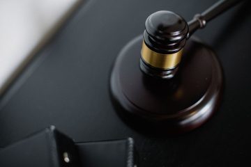 Marteau de justice posé sur un support en bois sombre
